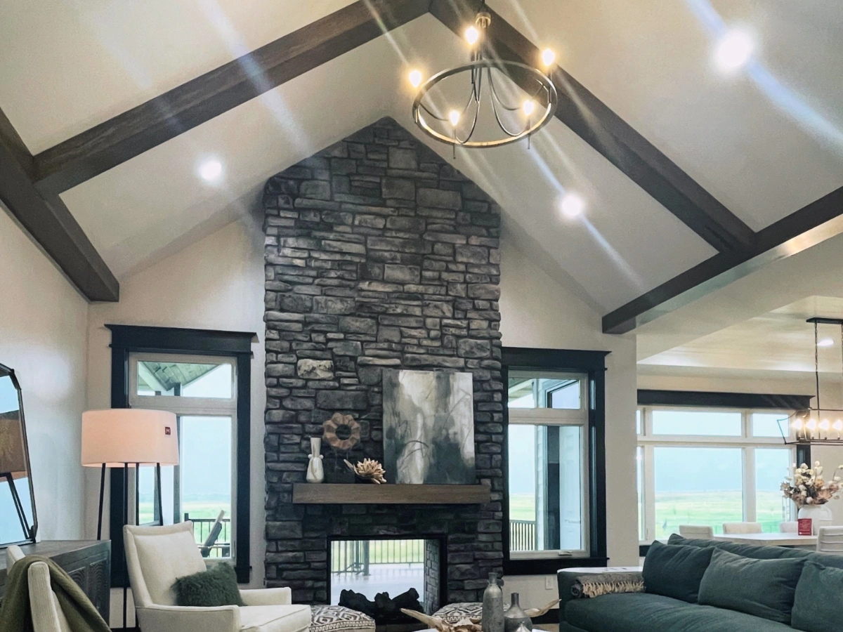 Completed living area with stone fireplace and lighting