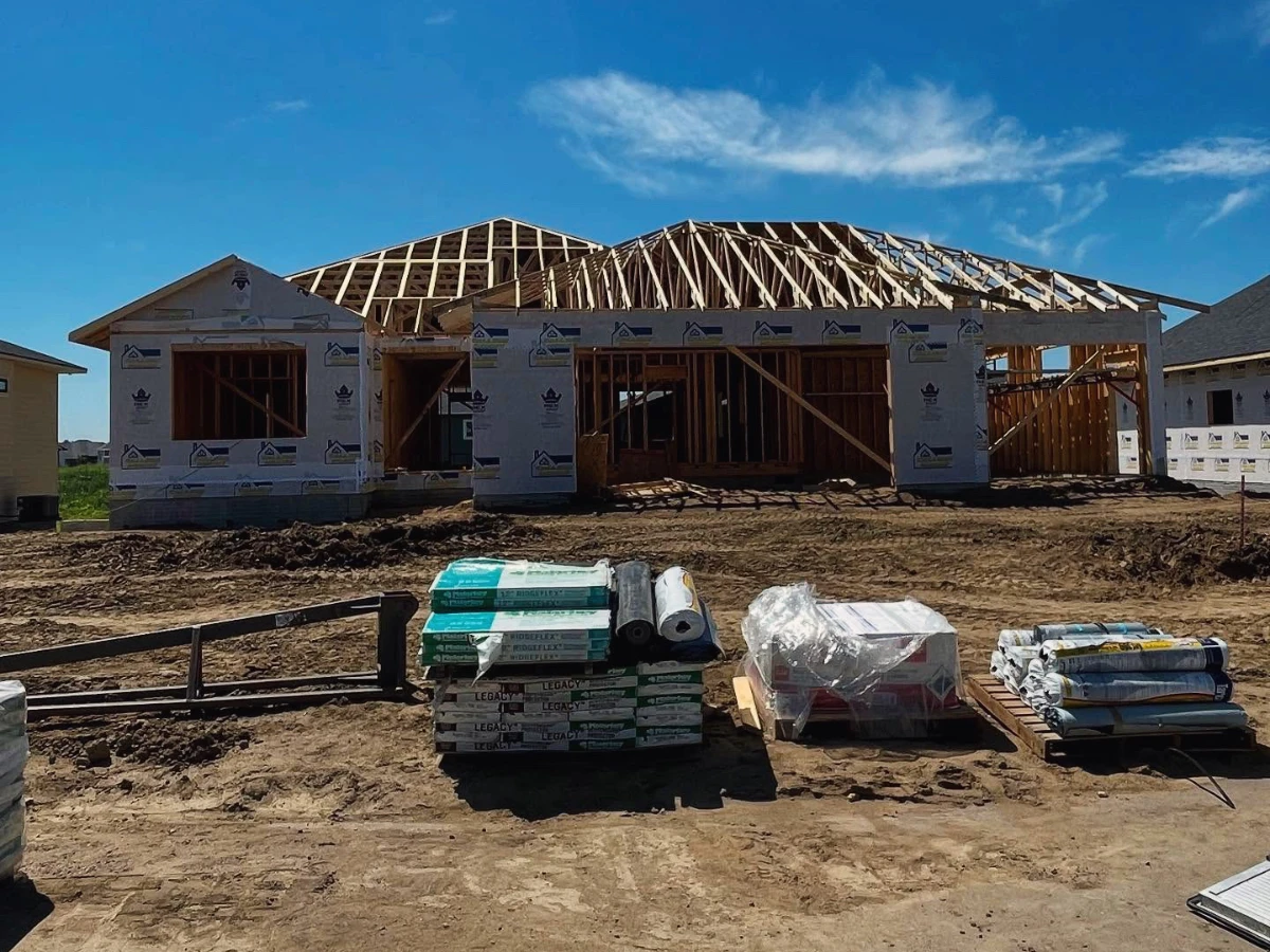 Custom home build in progress with supplies sitting on the ground